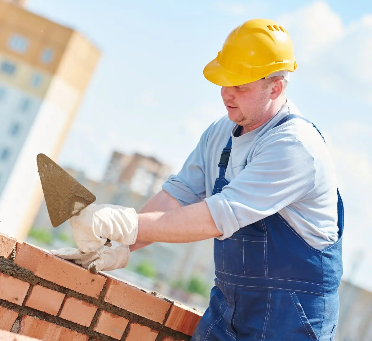 Maurer mit Helm bei der Arbeit. Symbolbild für Betriebshaftpflicht für Maurer